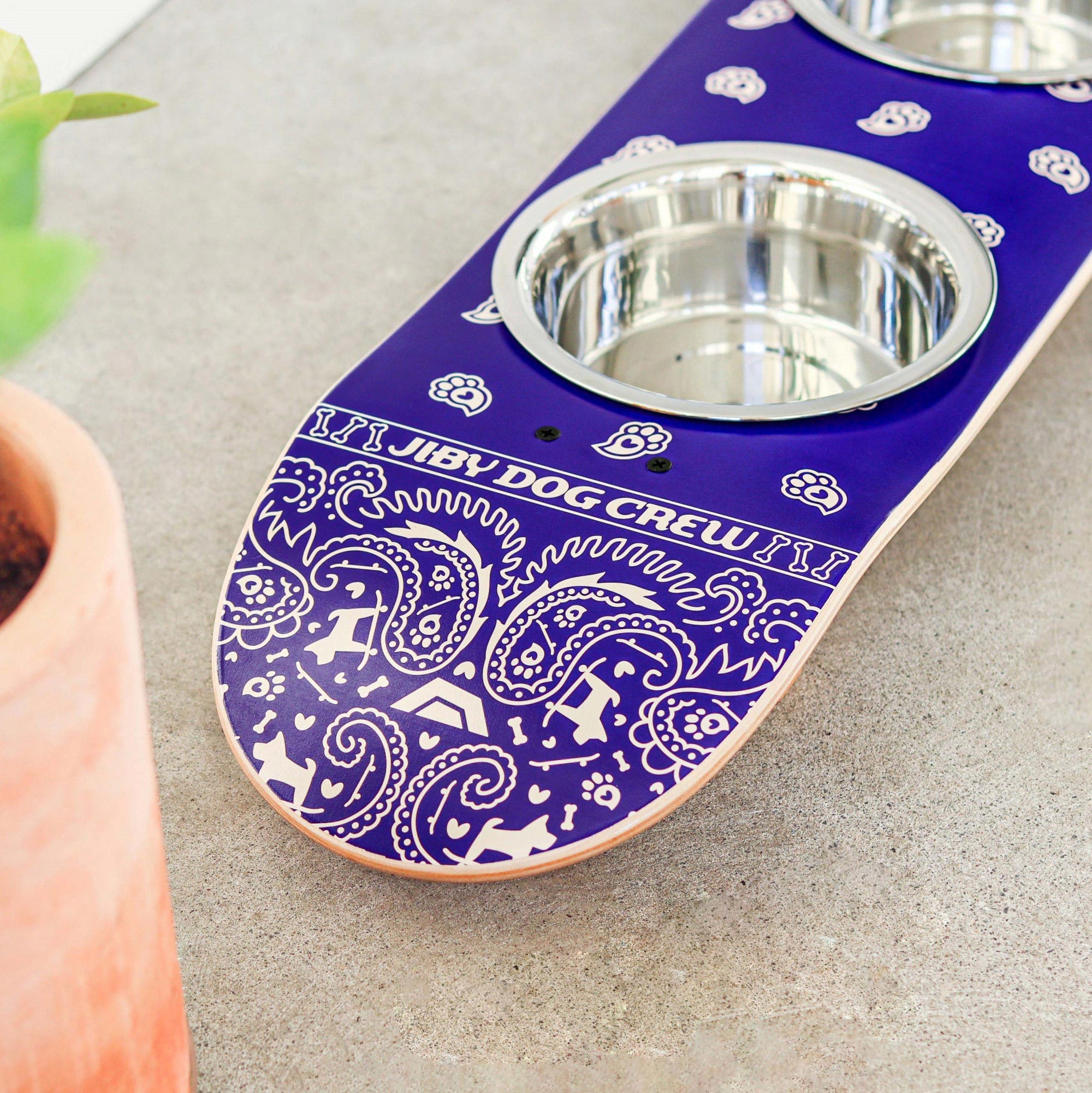 Skateboard dog bowl feeder stand handcrafted with custom designed art.